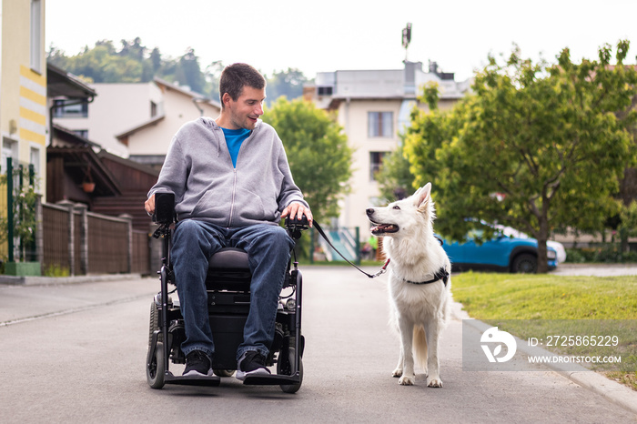 一个残疾人和他的服务犬，一只美丽的白色瑞士牧羊犬。