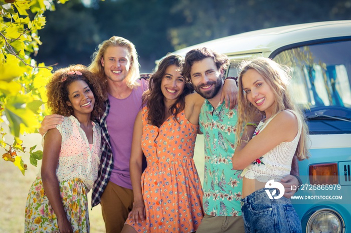 Group of friends standing together near campervan