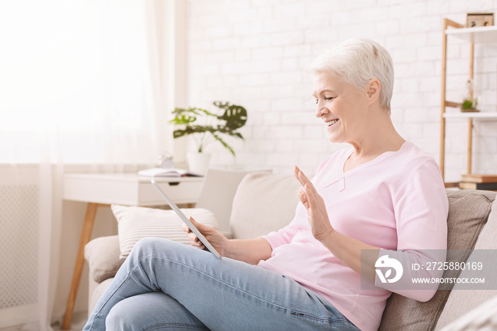 快乐的老年女性通过数字平板电脑与家人交谈