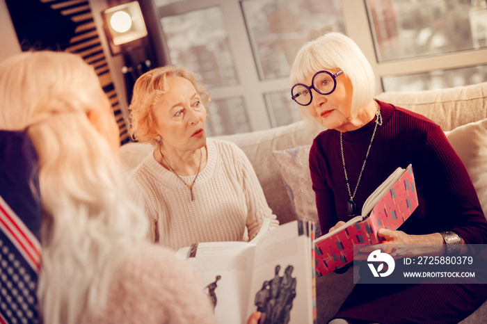 Pleasant aged women having a book club meeting