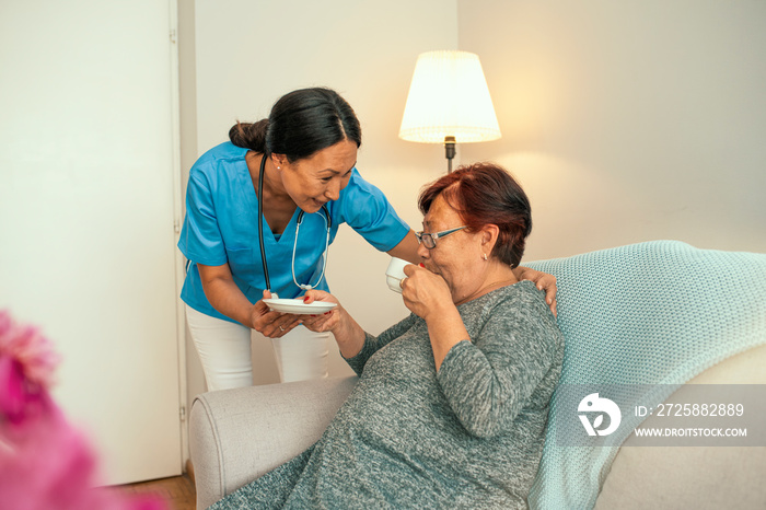 Shot of a young caregiver caring for her elderly patient in her home. Dementia and Occupational Ther