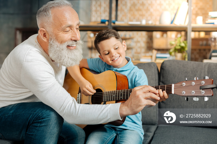 慈爱的爷爷教孙子如何握吉他