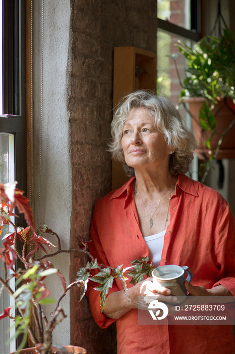 Senior woman looking through window