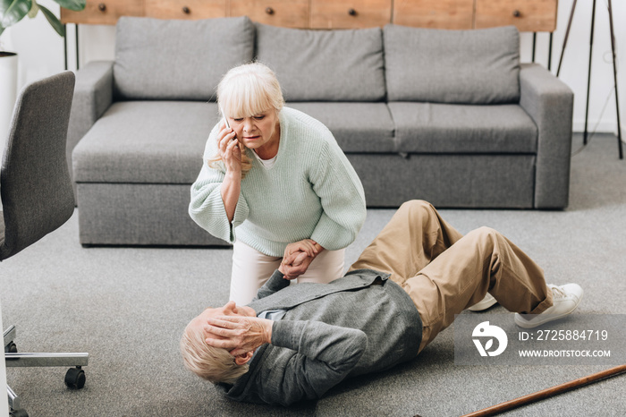 senior woman helping to husband who falled down on floor