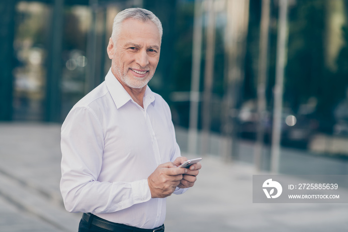 Photo of good mood smiling age businessman wear white shirt typing modern gadget outside city street