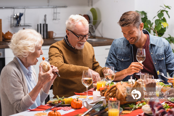 Selective focus of man holding wine near family and daughter during celebration thanksgiving