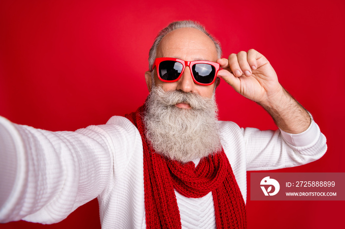 时尚老年圣诞老人自拍戴太阳眼镜针织套头衫隔离红色背景