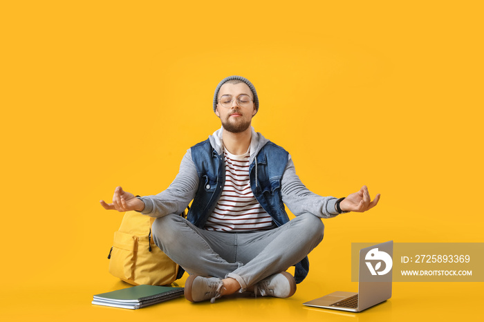 Meditating male student on color background