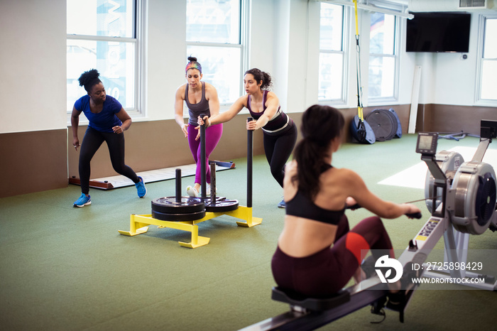 Athletes exercising with exercise equipment in gym