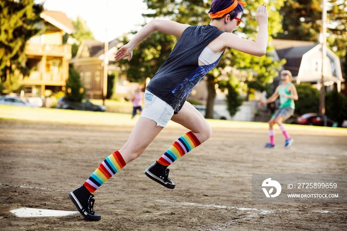 Teenage girl running on baseball ground