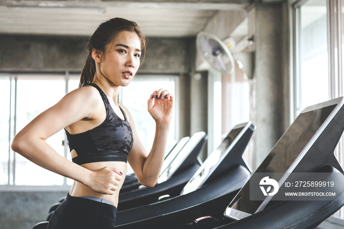 Fitness woman running on treadmill in gym