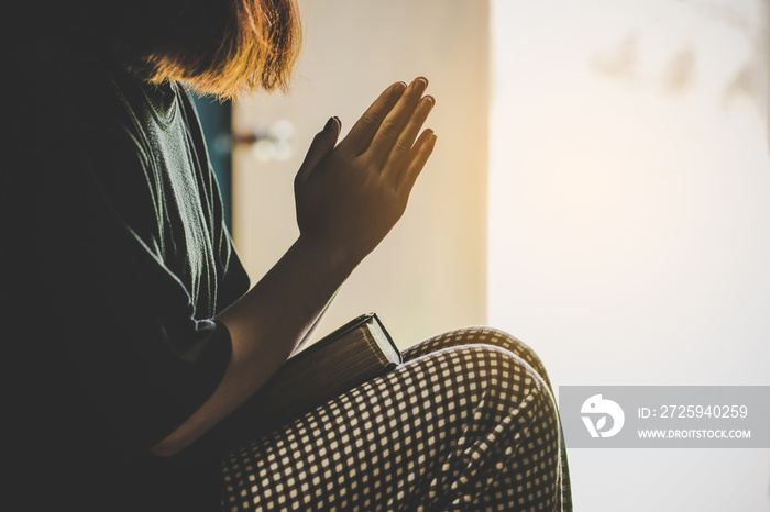 Teenage girl hand with Bible praying in the morning.