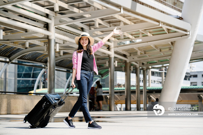 Asian women tourist wear casual clothes wear hat and black luggage. Travel during long summer holida