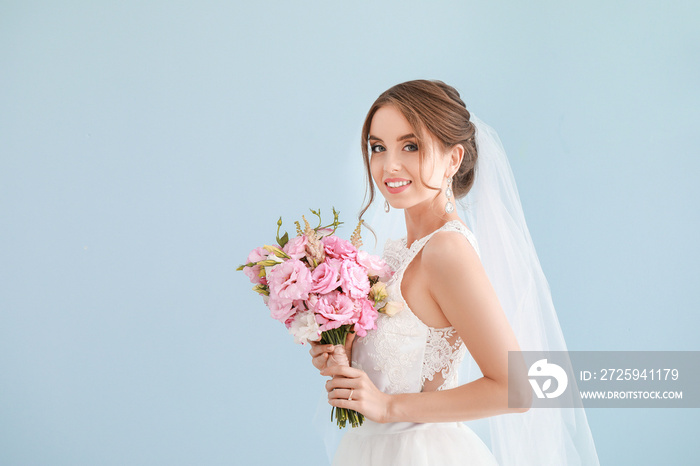 美丽年轻新娘的肖像，浅色背景上有结婚花束