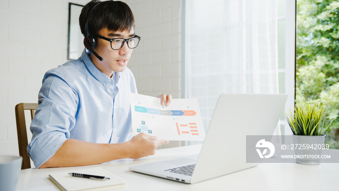 Young Asia businessman using laptop talk to colleagues about plan in video call while smart working 