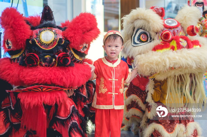 Cute smiling little 2 - 3 years old Asian toddler baby boy child in traditional red Chinese costume 