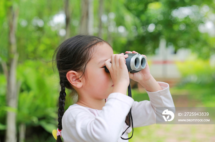 田野里的小女孩在户外大自然中用双筒望远镜观看。探索和冒险骗局