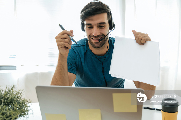 Distance education. handsome man teacher with headset showing blank paper sheet for teaching online 