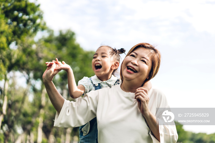 快乐的祖母和可爱的小女孩在夏季公园一起放松的肖像。家人和朋友