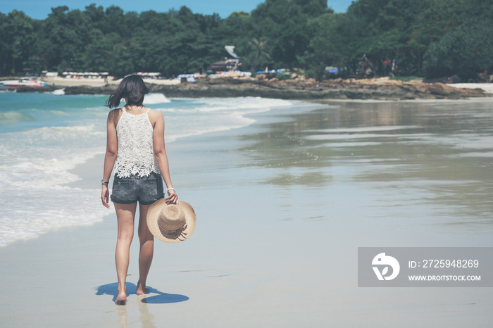 旅行亚洲女人在海滩上行走