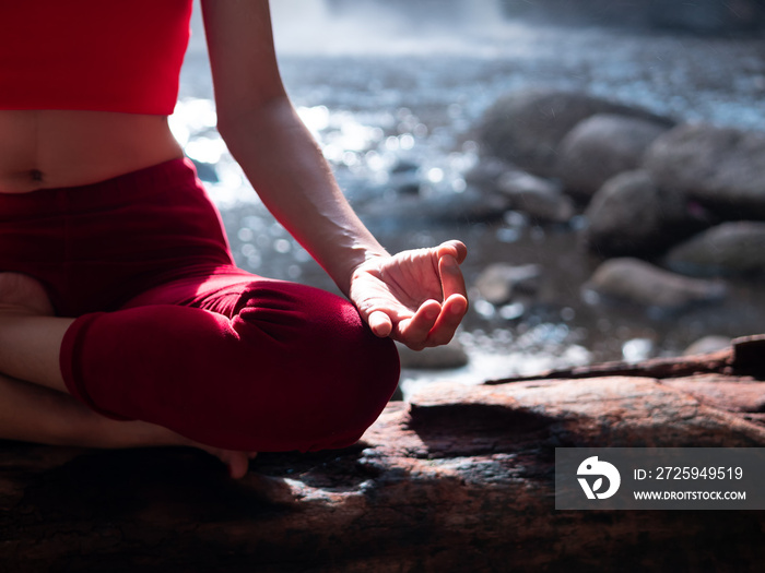 Asian woman practicing or doing yoga at the waterfall. Beautiful Landscape, Natural background, Thai