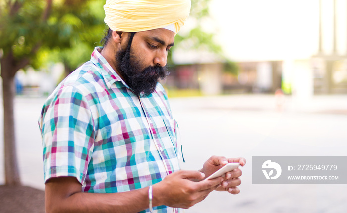 Indian with turban using mobile phone in outdoors