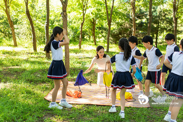 快乐的小学生和老师在户外野餐