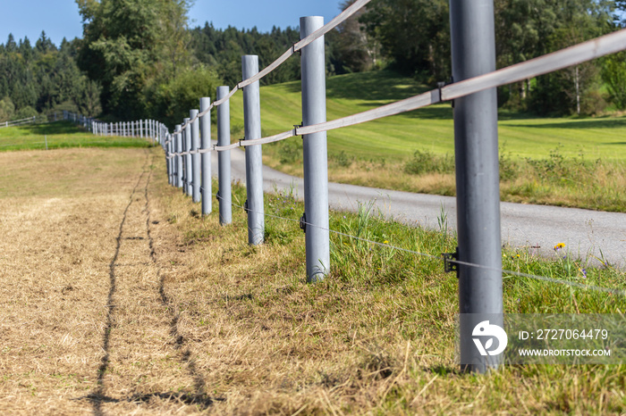 An electric fence of a cow meadow