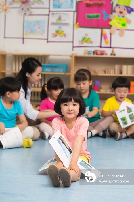 幼儿园儿童坐在地板上看故事书