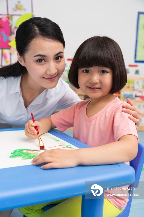 幼儿园女老师辅导儿童画画