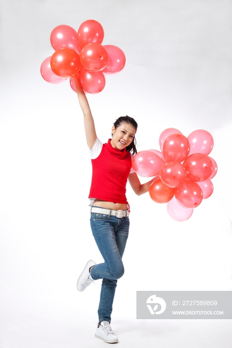 棚拍年轻女人举着红色气球
