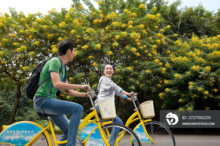 年轻大学生在校园里骑车