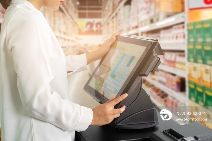 Cropped shot of female cashier staff standing and working with POS or point of sale machine at count