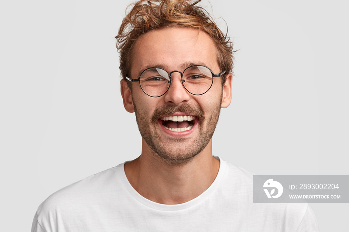 戴着圆眼镜的快乐时尚男性的特写镜头，脸上带着积极的笑容，很高兴收到sa