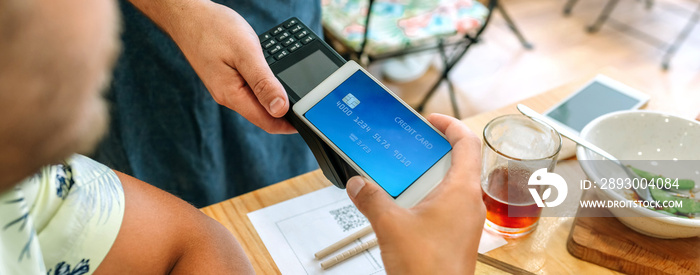 Closeup of unrecognizable customer paying the restaurant bill with a virtual mobile card