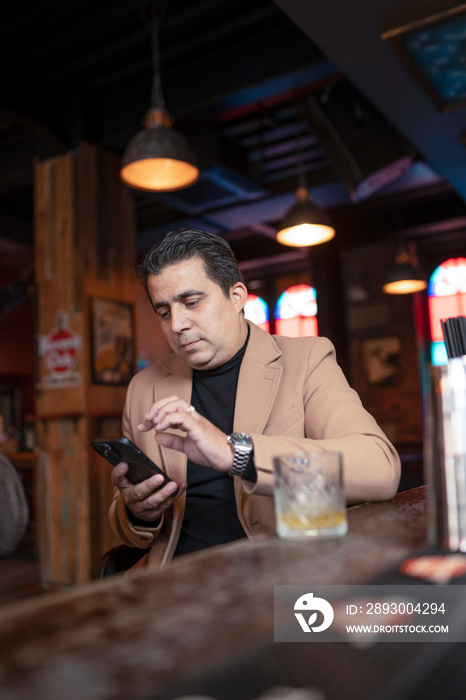 Man using smart phone in bar