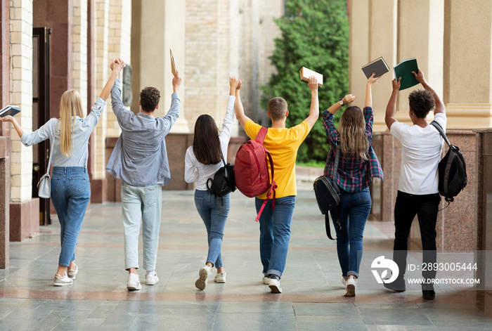 我们通过了考试。学生们在校园里举起双手行走