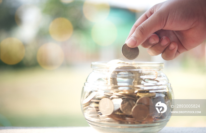 手把硬币扔到罐子里。退休计划保险储蓄的概念。