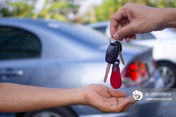 销售机构正在出售汽车并将钥匙交给新车主。出售汽车或租车