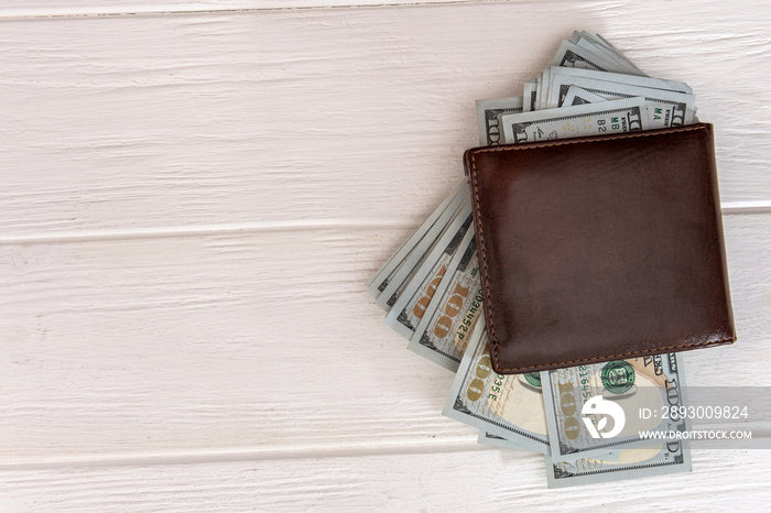 Dollars banknotes in a dark leather wallet