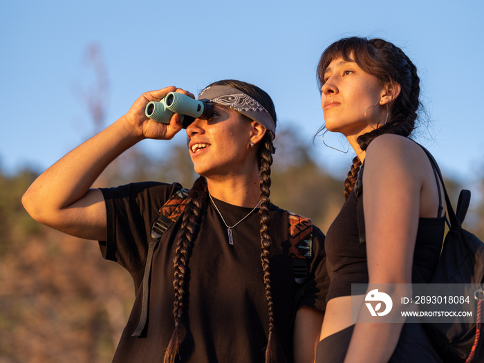 Young native friends birding in the forest