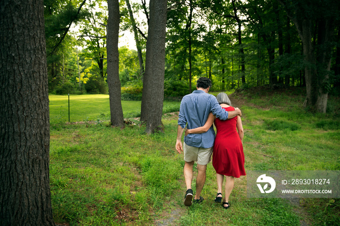 Rear view of mother and son walking in forest