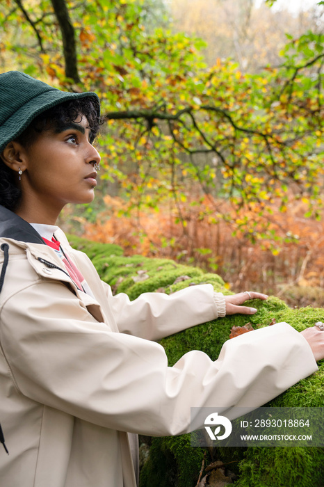 Woman touching moss in forest