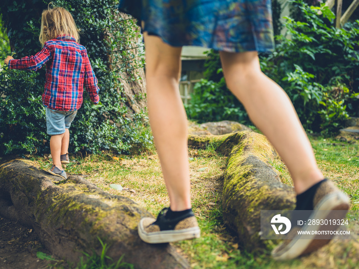 Mother and toddler balancing on a log