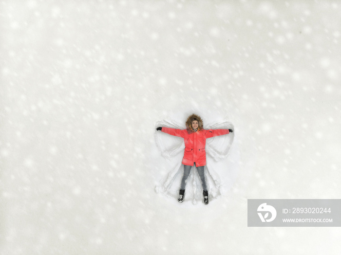 Girl lies in the snow - top view