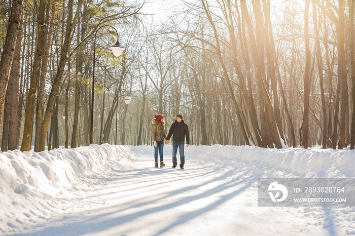情侣牵着手，冬天在路上，享受漫步，一对恩爱的情侣。Hu