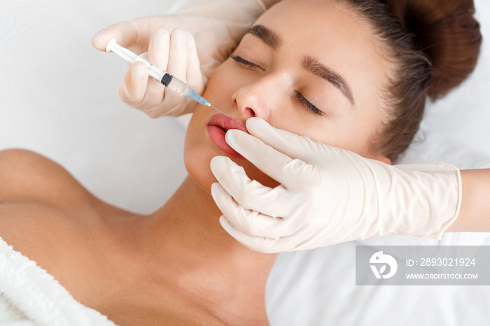 Beauty injection. Woman making correction form the upper lip