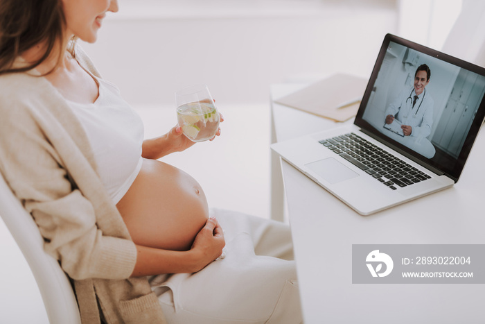 Relaxed smiling young mom is looking at monitor