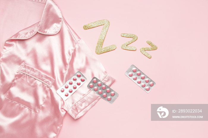 Composition with pajamas and sleeping pills on color background