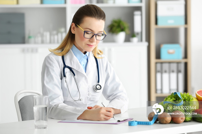 Young female nutritionist working in her office